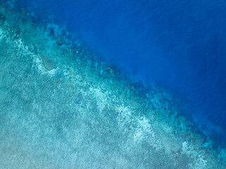 Aerial bird's eye view of the reef crest, edge or border between the open blue ocean and the...