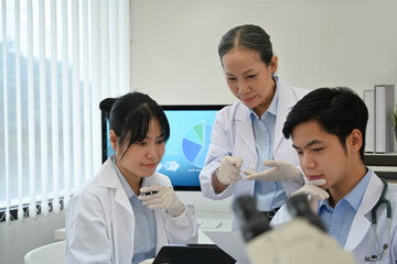 A team of professional Asian scientists or researchers have a medical research meeting in the lab.