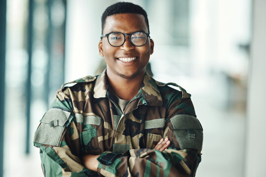 Portrait of soldier with smile, confidence and pride at army building, arms crossed and happy professional. Military career, security and courage, black man in camouflage uniform at government agency