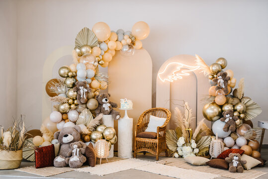 Arch with bears. Trendy cake for celebration baptism. Delicious reception at birthday party. Photo - wall decoration angel wings, beige, brown, golden balloons, autumn decor with dry leaves.