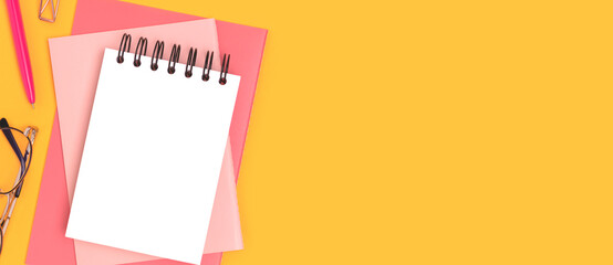 Banner with blank notepad mockup and stationery on a yellow background.