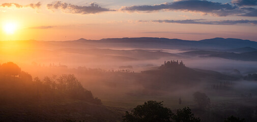 Fototapeta na wymiar Wide banner panorama of the famous Podere Belvedere in Tuscany at sunrise