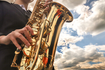 street musician playing the saxophone on a bright sunny day - obrazy, fototapety, plakaty