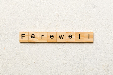 farewell word written on wood block. farewell text on table, concept