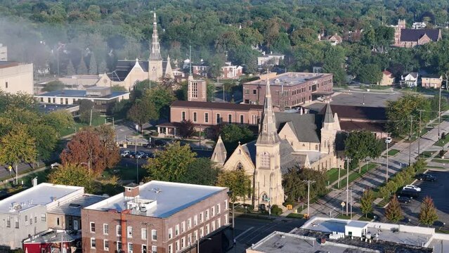 A rotating parallax aerial view of churches in downtown Saginaw, Michigan on a foggy late summer morning.  	