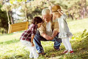 Grandfather and his grandchildren playing in the park