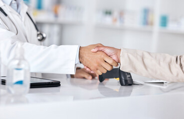 Pharmacist, doctor and shaking hands for pharmacy, medical support and customer. services at desk. Professional healthcare worker and patient handshake, thank you and success with medicine in retail