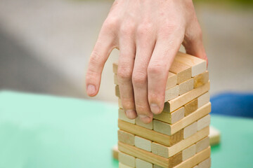close-up of a child's hand playing wood blocks stack game