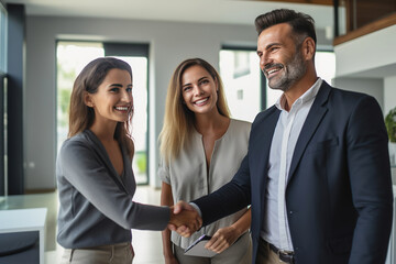Couple shaking hands with a real estate agent after purchasing a home - obrazy, fototapety, plakaty