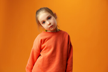 Portrait of upset little girl against yellow background