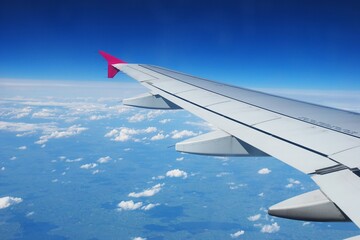 Obraz premium Airplane wings in blue sky 