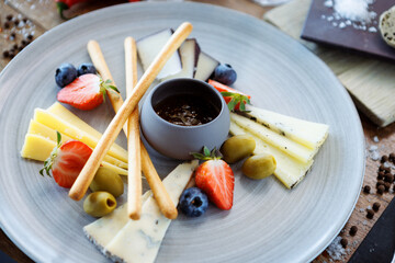 Cheese platter for two: Goat cheese cream, gorgonzola, camembert, grissini and fig jam. Delicious healthy Italian traditional food closeup served for lunch in modern gourmet cuisine restaurant - 646859644