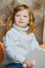 a girl with curly hair in a white knitted sweater. background for a Happy New Year and a Merry Christmas. winter holidays