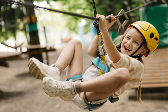 Happy six year girl at climbing activity in high wire forest park