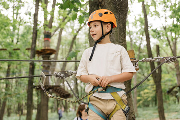 Six year boy on rope-way in forest