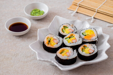 Maki sushi rolls on white plate with soy sauce and wasabi-Japanese food