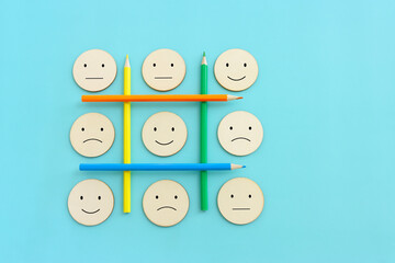 Fototapeta premium Top view image of pencils with of happy and sad face. concept of happiness emotion and satisfaction