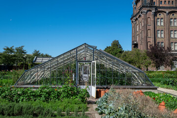 a small greenhouse stands in a garden
