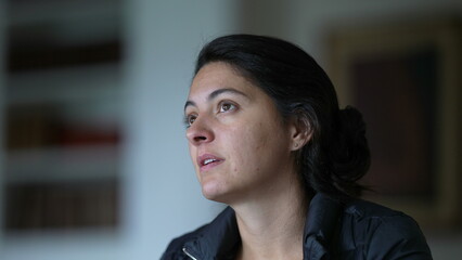 Candid woman conversing with people off-camera, close-up face of person interacting and engaged in...