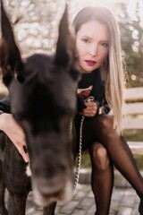 A woman walks with her Great Dane in an urban setting, enjoying the outdoors and the company of her...