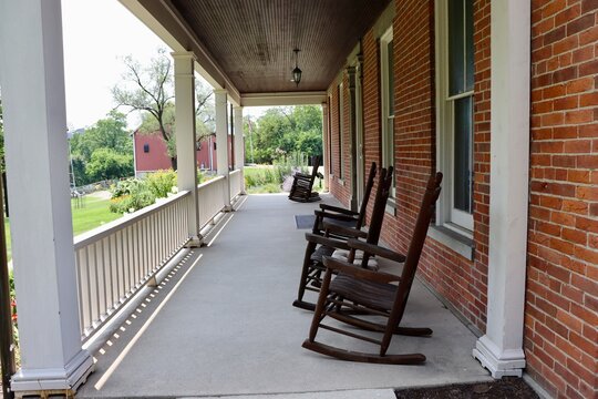 The rocking chairs on the porch of the house.