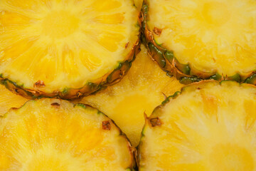 Pineapple juicy yellow slices as a background.