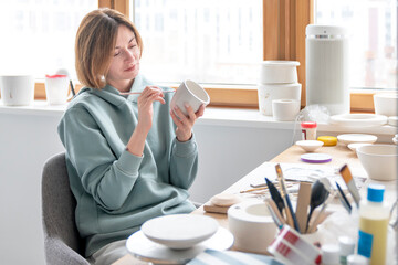 Close-up Image portrait of female ceramic artist working with clay mug and making Ceramic Product. Professional Ceramic Artist makes handcrafted products. Small business and hobby concept