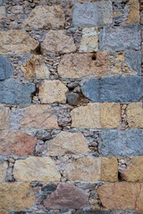 Detalle de muro de piedra de tamaños y colores variados y mortero