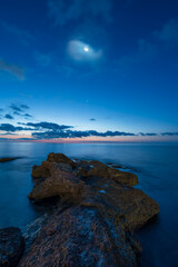 Luna encima del mar en la noche