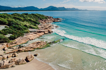Beach, rocks and transparent ocean with small waves in Brazil. Aerial view of tropical beach in...