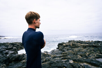 happy surfer in the coast with his red surfboard