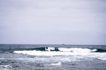 Fototapeta premium happy surfer in the coast with his red surfboard