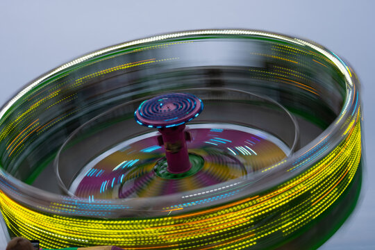 zero gravity ride at local fair or carnival at night long time exposure creating spinning motion like a spinning top movement and motion of yellow lights spinning horizontal image room for type 