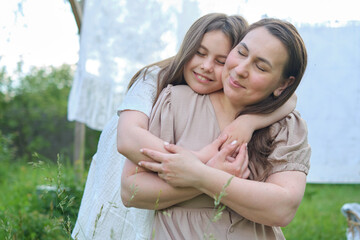As dusk falls, a mother s loving touch calms her young daughter, their hammock serving as a sanctuary in the garden.