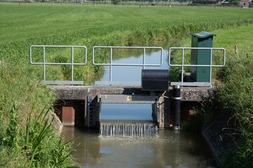 Closeup of a small weir in a stream for water level control in a Dutch polder