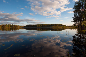 Autumn lake scenery with clouds reflected on the surface of water in the forests of Finland