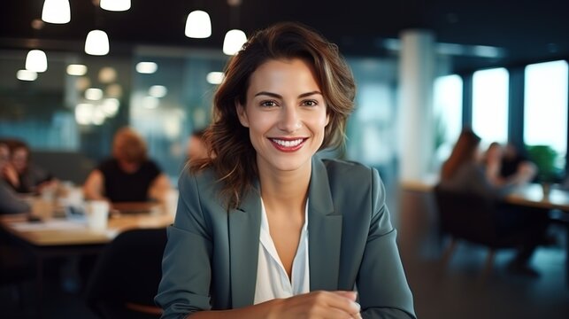 confident businesswoman sits at her computer at her desk with a positive attitude. While working, a beautiful, healthy female entrepreneur or a creative, trustworthy boss smiles