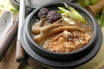 Soul-Warming Sam Gye Tang: 4K Image of Chicken Soup with Ginseng, Roasted Garlic, and Raisin Tree Nut - obrazy, fototapety, plakaty