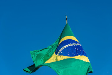 Brazilian flag fluttering in the blue sky on the 7th of September. Date of commemoration of the independence of Brazil.