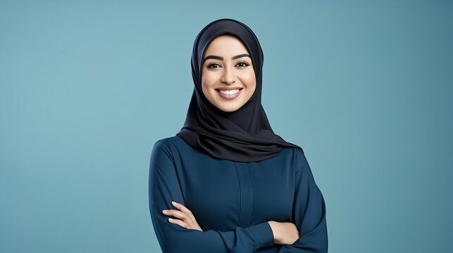 Young Confident Arabian Asian Muslim Woman In Abaya Hijab With Hands Crossed Folded Isolated On A Plain Blue Background Studio Portrait. Generative Ai