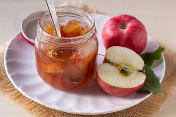 Apple jam in jar on wooden table