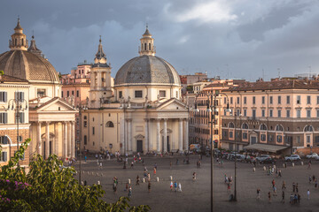 Moody, atmospheric cityscape view over Baroque churches and obelisk in the popular tourist landmark Piazza del Popolo in the historic old town.
