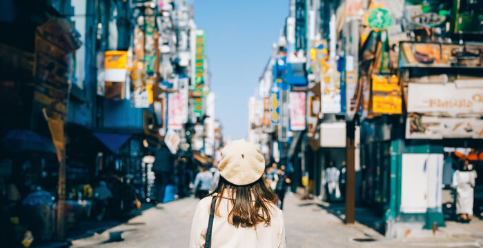 Asian girl standing out from the crowd at a city street in Japan.