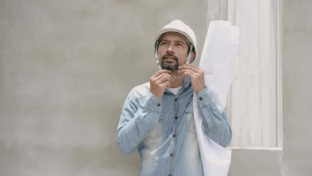 Male engineers standing inside houses under construction, man lifts  helmet puts them on their head, for safety when in area where there is construction all time, attach house plan paper yourself.