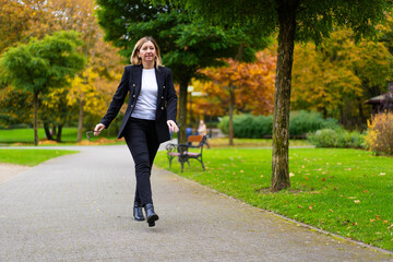 Beautiful businesswoman walking in city park

