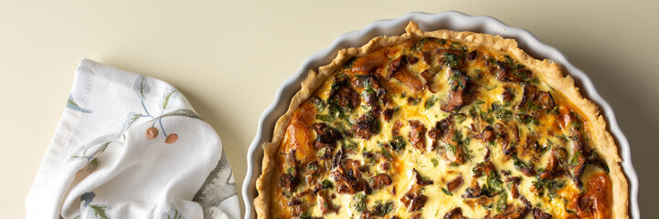 Homemade quiche with seasonal forest mushrooms Chanterelles in a round shape on a yellow...