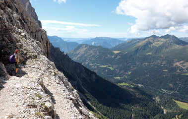 trail in the European alps in Northern Italy in summer and young female hiker