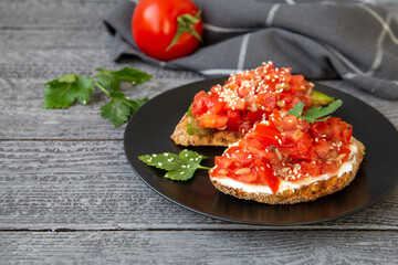 Bruschetta with cottage cheese, avocado, tomatoes, greens, white sesame seeds. Healthy food, rich in healthy fats, fiber, vitamins, antioxidants. Vegetarian food.