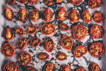 Cooked Sun Dried Tomatoes with Olive Oil, Garlic and Thyme on Baking Paper. View from Above.