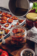 Coating of Freshly Cooked Sun Dried Tomatoes and Thyme with Olive Oil in a Glass Jar